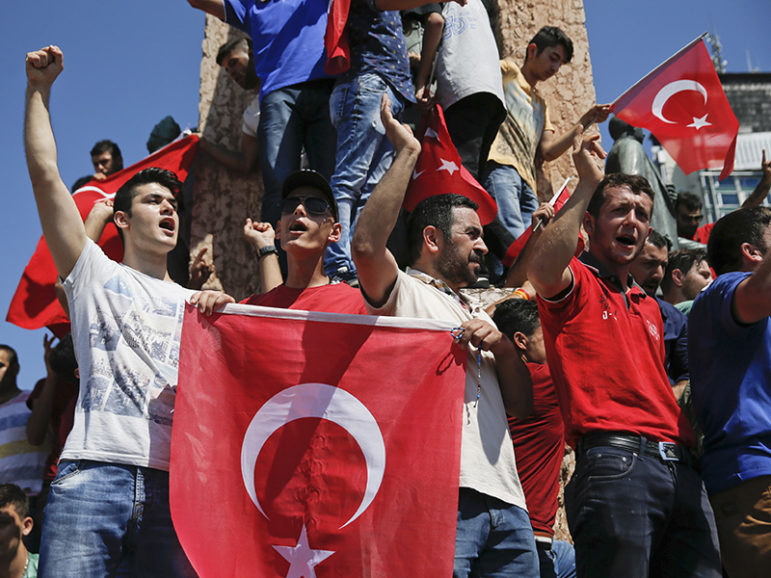 People wave Turkish flags as they stand around the Republic Monument in Taksim Square in Istanbul, Turkey, July 16, 2016.    Courtesy of REUTERS/Alkis Konstantinidis