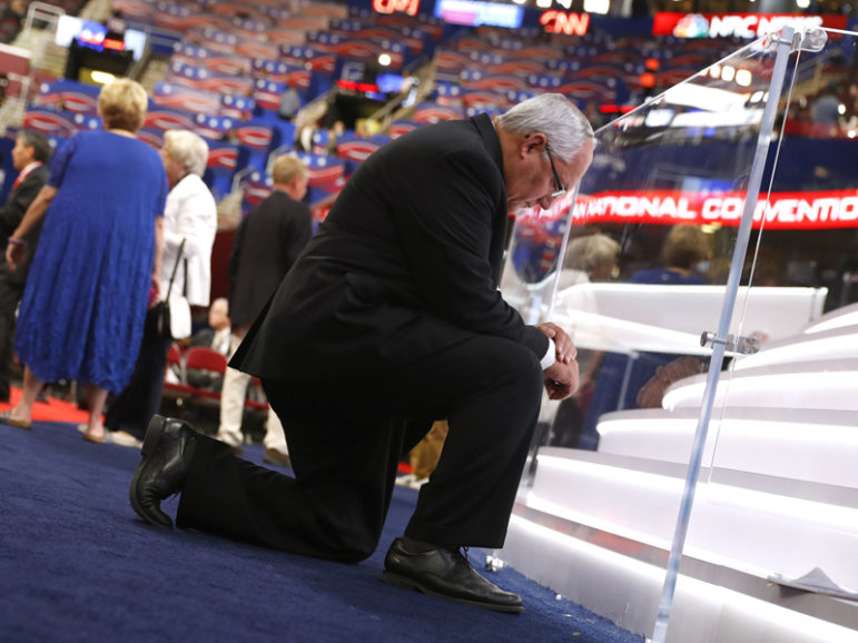 The Rev. Glenn Clary of the Anchorage Baptist Temple in Anchorage, Alaska, kneels in prayer in front of the stage during the third day of the Republican National Convention in Cleveland on July 20, 2016. Photo courtesy REUTERS/Aaron P. Bernstein. Editors: This photo may only be used with RNS-LUPFER-COLUMN published July 28, 2016.