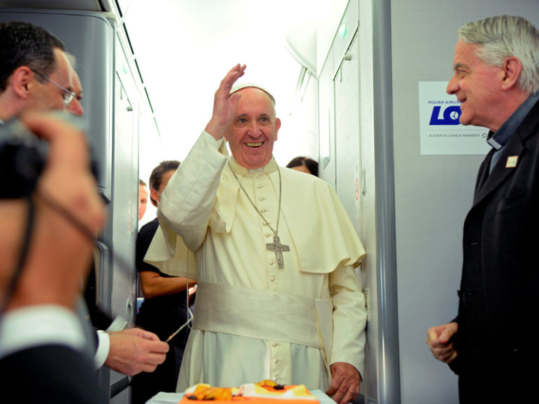 Pope Francis, center, waves next to newly retired Vatican spokesman Rev. Federico Lombardi, right, during a press conference on a plane after the pope's visit to Krakow, Poland, for World Youth Day, on July 31, 2016. Photo courtesy REUTERS/Filippo Monteforte/Pool. Editors: This photo may only be used with RNS-FRANCIS-POLAND published July 31, 2016.