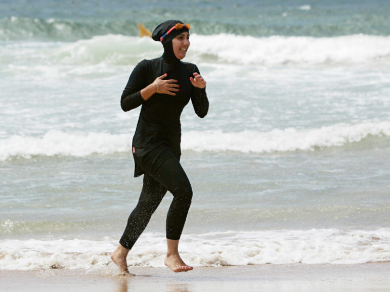 Twenty-year-old trainee volunteer surf lifesaver Mecca Laalaa runs along North Cronulla Beach in Sydney, Australia, during her Bronze medallion competency test on Jan. 13, 2007. Specifically designed for Muslim women, Laalaa's body-covering swimming costume has been named the 