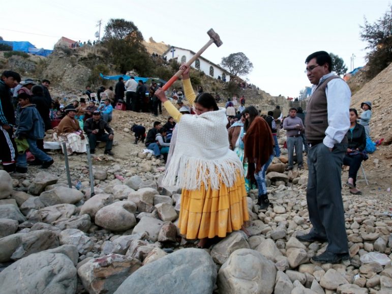 An Aymara woman tries to break a rock with a sledgehammer as part of the celebration of the Virgin of Urkupina on Aug. 15, 2016, on the outskirts of La Paz. Photo by David Mercado/REUTERS