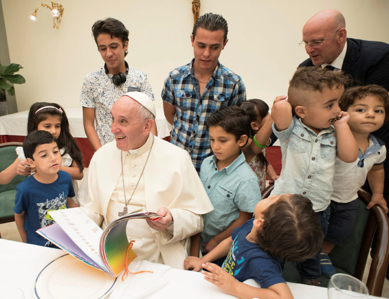 Pope Francis sits with  Syrian refugees at the Vatican on August 11, 2016. (L'Osservatore Romano/Pool Photo via AP)