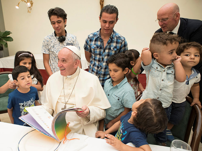 Pope Francis sits with some  Siryans refugees at the Vatican on August 11, 2016. (L'Osservatore Romano/Pool Photo via AP)