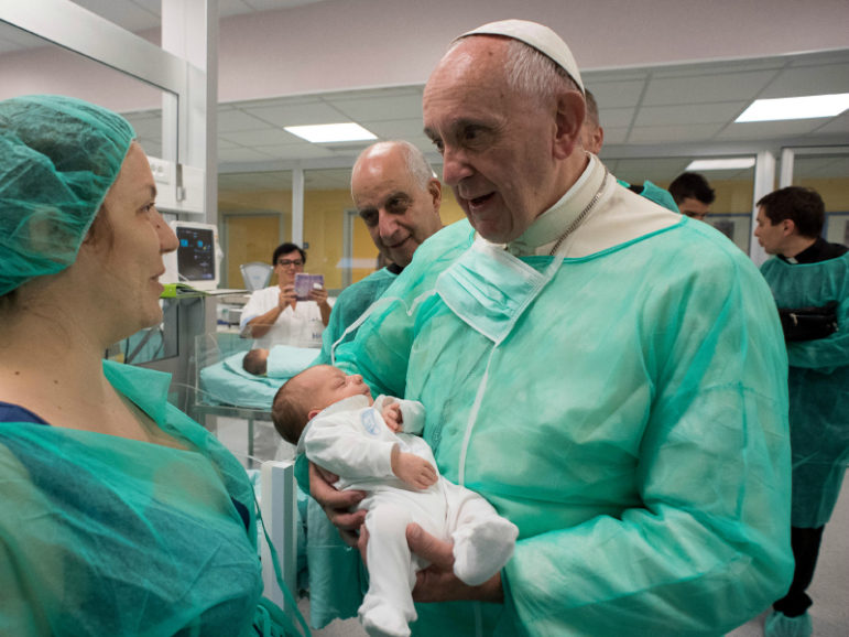 Pope Francis holds an infant at the neonatal unit  as he visits the San Giovanni hospital in Rome, September 16, 2016. Photo by Osservatore Romano via Reuters. 