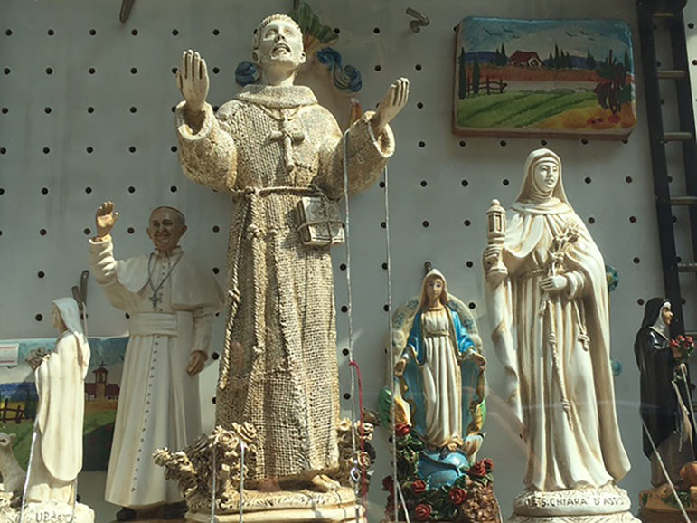 Statues of Pope Francis and his namesake, St. Francis, fill the windows of souvenir stores in Assisi. RNS photo by Josephine McKenna