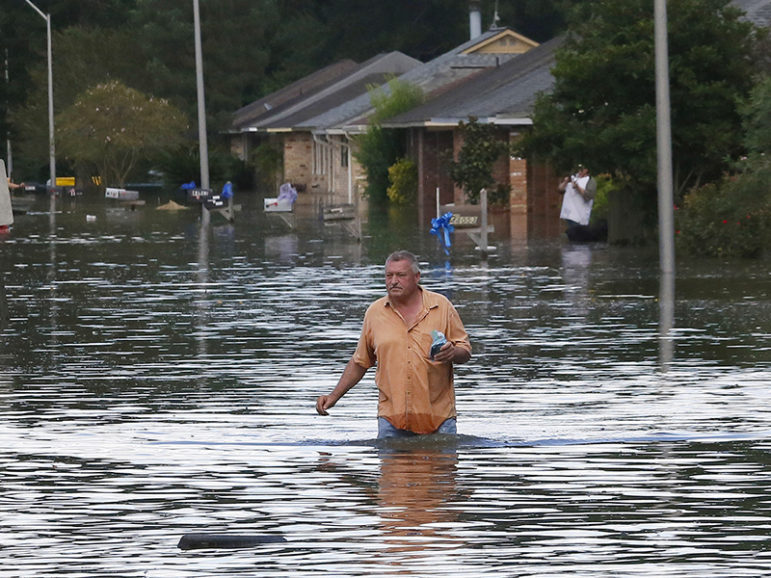 A man wades through a flooded street in Ascension Parish, La., on Aug. 15, 2016.  Photo courtesy of REUTERS/Jonathan Bachman
*Editors: This photo may only be republished with RNS-GRENIER-OPED, originally transmitted on Sept. 1, 2016.