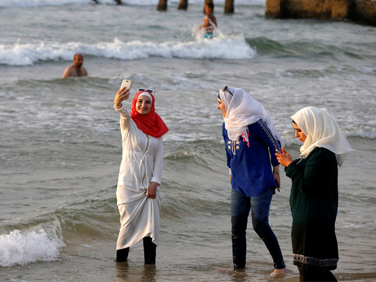 A Muslim woman wearing a hijab takes a selfie as she stands in the Mediterranean Sea at a beach in Tel Aviv, Israel, on Aug. 30, 2016. Photo courtesy of REUTERS/Baz Ratner
*Editors: This photo may only be republished with RNS-NASSER-OPED, originally transmitted on Sept. 8, 2016.
