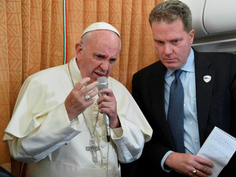 Pope Francis speaks to journalists, next to Vatican spokesman Greg Burke, on his flight back to Rome following a visit in Georgia and Azerbaijan, October 2, 2016. Pool photo via Reuters/Luca Zennaro