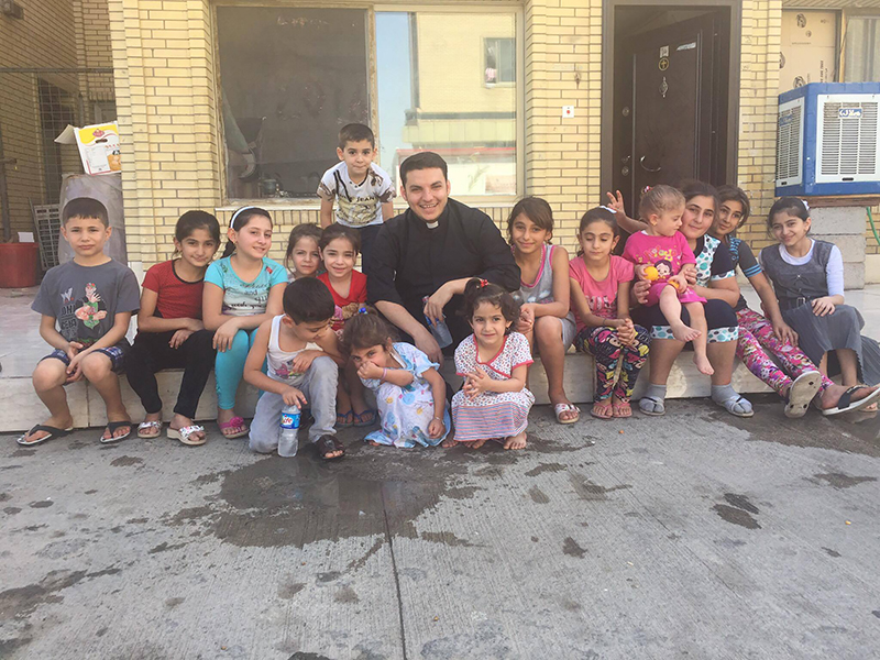 Priest Martin Banni with a group of displaced children from the Christian towns in Nineveh in Erbil. Banni spent much time playing with children, and telling them stories from the Bible. Photo courtesy of Martin Banni
