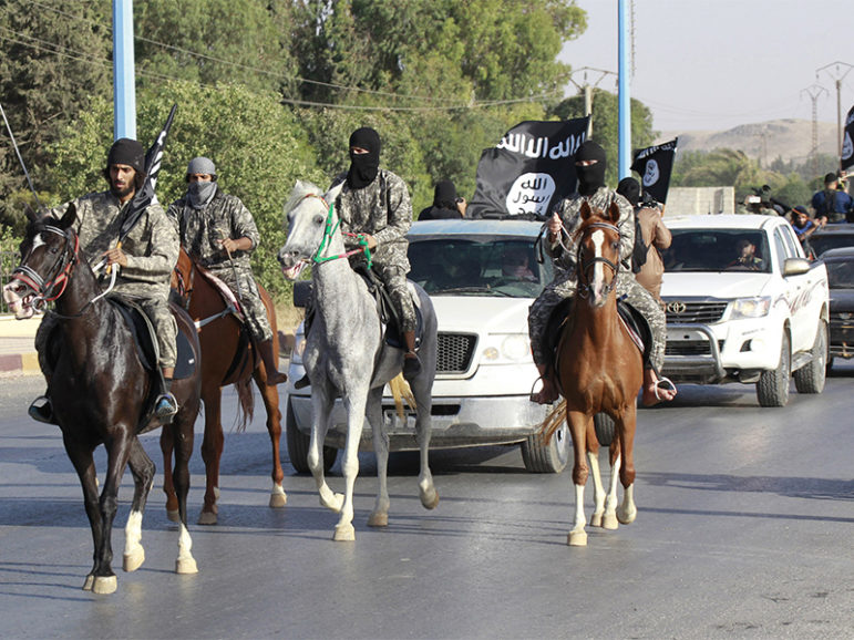 So-called Islamic State fighters ride horses as they take part in a military parade along the streets of Syria's northern Raqqa province on June 30, 2014. Photo courtesy of Reuters/Stringer