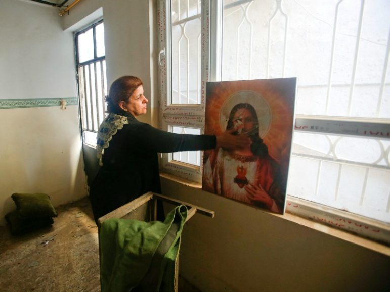 A Christian woman inspects a home Nov. 23, 2016, in the town of Bartella east of Mosul, Iraq, after it was liberated from Islamic State militants. Photo by Khalid al Mousily/REUTERS
