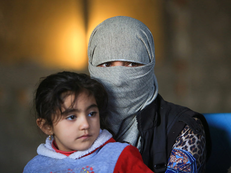 A displaced woman from the minority Yazidi sect, who was kidnapped by Islamic State militants of Tal Afar but managed to flee, holds a child in Duhok province, northern Iraq, November 24, 2016. Photo courtesy of REUTERS/Ari Jalal