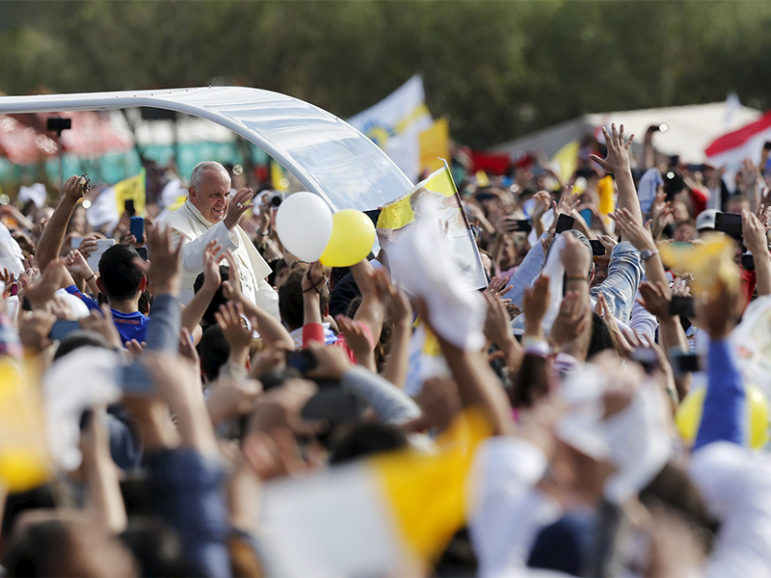 Pope Francis waves to the crowd of faithful from a popemobile as he arrives to celebrate mass in Luque, on the outskirts of Asuncion, Paraguay, on July 12, 2015. Photo courtesy of Reuters/Andres Stapff