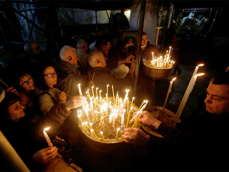 Christian worshipers light candles inside the Church of the Nativity in the West Bank city of Bethlehem on Nov. 26, 2016. Photo courtesy of Reuters/Mussa Qawasma