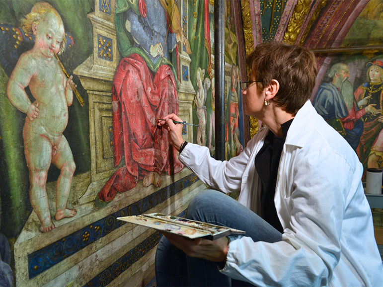 Art restorer Stefania Culesanti puts finishing touches on a red robe in the music section of the Hall of the Liberal Arts in the Borgia Apartments in the Vatican Museums on Dec. 12, 2016. Photo courtesy of Chris Warde-Jones