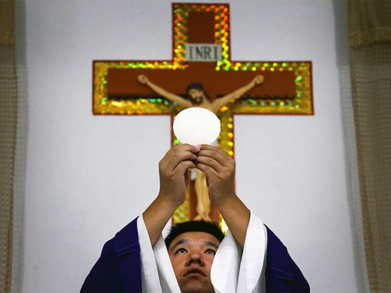 Catholic priest Liu Yong Wang performs holy communion in a make-shift chapel in the village of Bai Gu Tun, located on the outskirts of the city of Tianjin, around 70 km (43 miles) south-east of Beijing on July 17, 2012. Photo courtesy of REUTERS/David Gray