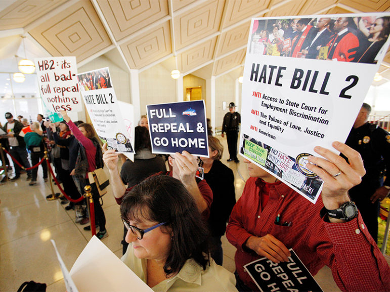 Opponents of North Carolina's HB2 law limiting bathroom access for transgender people protest in the gallery above the state's House of Representatives chamber as the Legislature considers repealing the controversial law in Raleigh, N.C., on Dec. 21, 2016. Photo courtesy of Reuters/Jonathan Drake