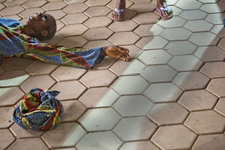 A worshipper falls to the floor during a deliverance ceremony at the Mountain of Fire and Miracle Ministries prayer service called “Power Must Change Hand” in Lagos, Nigeria. Photo by Andrew Esiebo, used with his permission. 