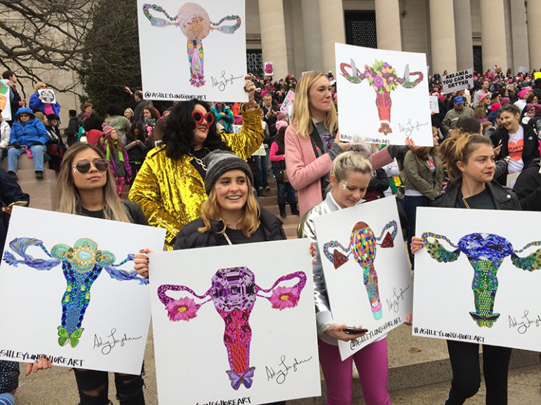 A group of women hold up their artwork. They were among the many to carry images of the uterus in protest against statements by President Trump, at the Women's March on Washington near the National Mall on Jan. 21, 2017. RNS photo by Jerome Socolovsky