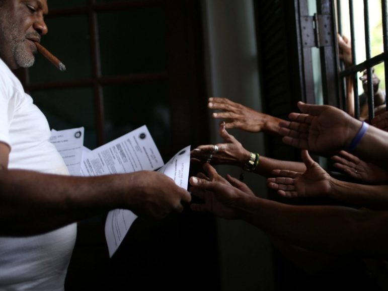 Followers of the Yoruba religion receive a sheet of paper with recommendations based on their annual predictions for the new year, after a news conference Jan. 3, 2017, in Havana. Photo courtesy of Reuters/Alexandre Meneghini