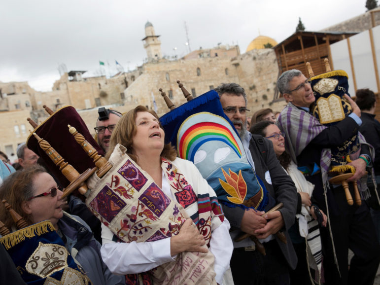 Anat Hoffman (second from left in foreground), chair of Women of the Wall, an activist group that is challenging the Orthodox monopoly over rites at the Western Wall, holds a Torah scroll during a monthly prayer at the site on Nov. 2, 2016. The Western Wall is Judaism's holiest prayer site. Photo courtesy of Reuters/Michal Fattal