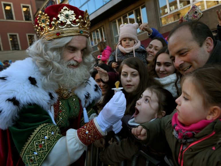 A man dressed as one of the Three Kings receives a baby pacifier from a girl during the Epiphany parade Jan. 5, 2017, in Gijon, Spain. Photo by Eloy Alonso/REUTERS