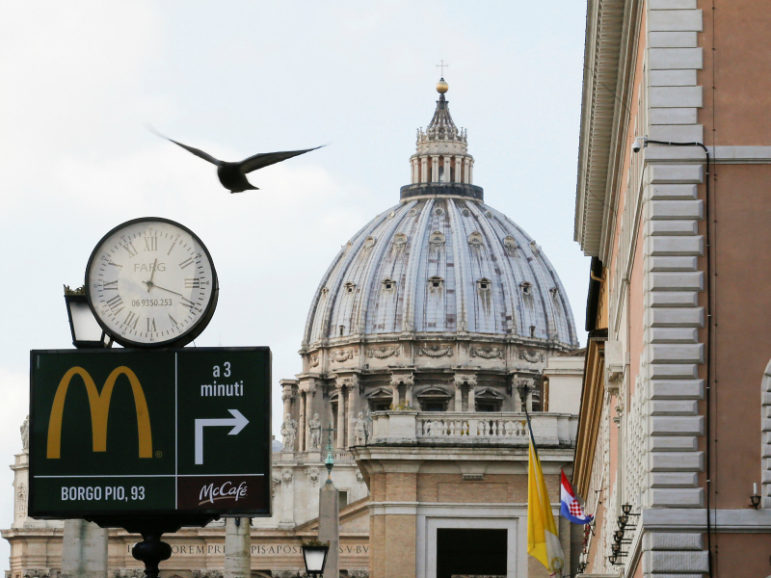 A sign in front of St. Peter's Basilica points to the newest McDonald's  restaurant in Rome, next to the Vatican. Jan. 3, 2017. Photo courtesy of Reuters/Alessandro Bianchi 