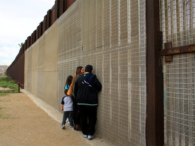 Families separated by the two countries chat along the U.S.-Mexico border fence at Border Field State Park, Calif., on Nov. 19, 2016.  Photo by Mike Blake/Reuters