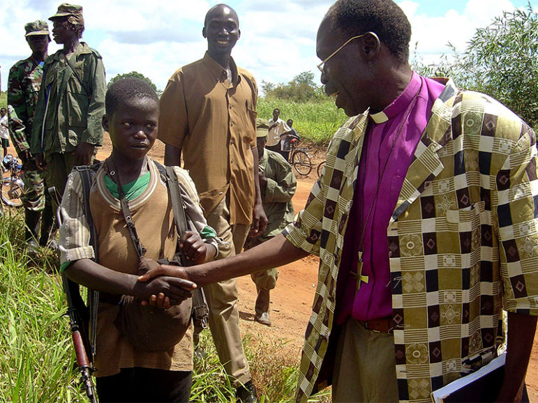 Kitgum Bishop Benjamin Ojwang shakes hands with a rebel child soldier of the Lord's Resistance Army in Kitgum district, northern Uganda, on Sept. 8, 2006.  Photo courtesy of Reuters/Hudson Apunyo