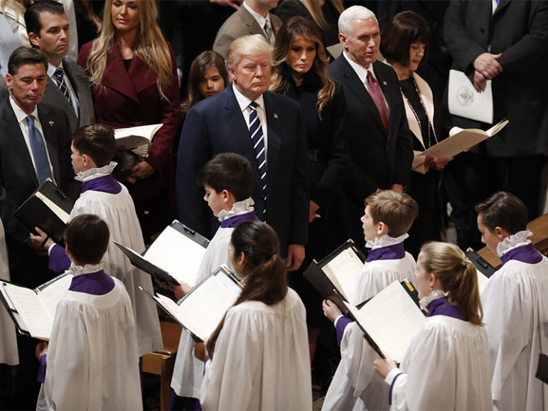 President Trump, center, watches acolytes pass by as he is accompanied by his wife Melania, Vice President Mike Pence and his wife Karen, right, during a prayer service at Washington National Cathedral the morning after his inauguration, in Washington, D.C., on Jan. 21, 2017.   Photo courtesy of Reuters/Carlos Barria