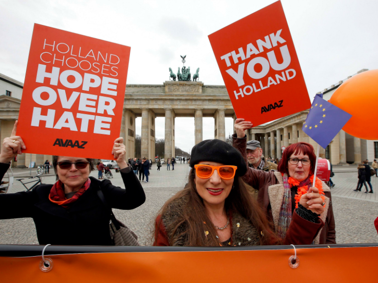 People hold placards to support the election results in the Netherlands during a demonstration in front of the Brandenburg Gate on March 16, 2017, in Berlin. Photo by Fabrizio Bensch/Reuters