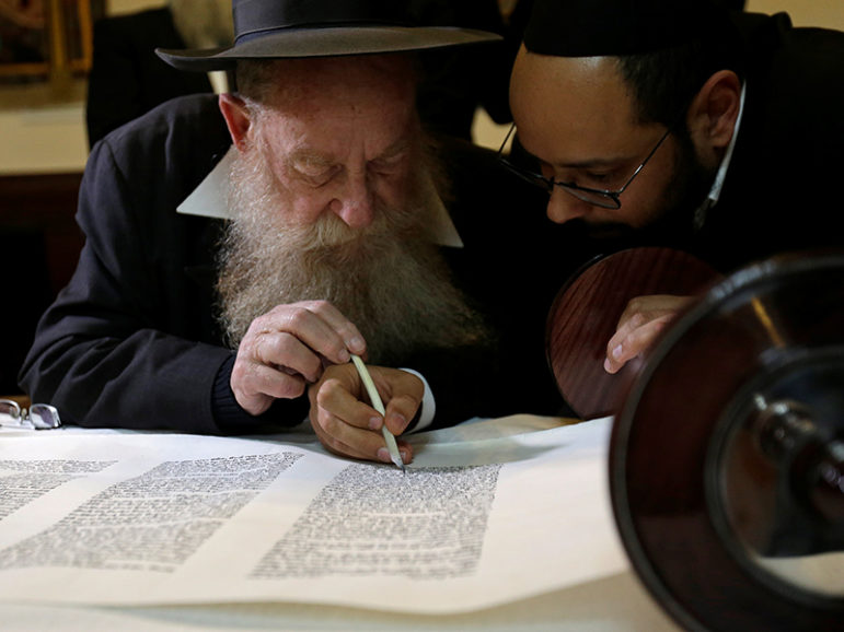Members of the Czech Jewish Community write final words in a new Torah scroll during a ceremony in the medieval Old-New Synagogue in Prague March 19, 2017. Photo courtesy of REUTERS/David W Cerny