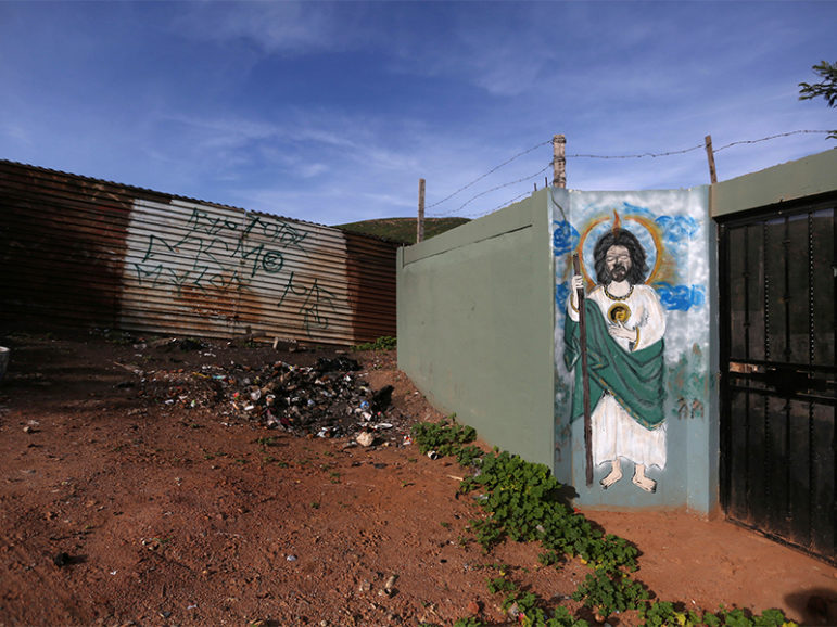 A painting of Jesus Christ is seen on the wall of a house, next to a section of the border fence separating Mexico and the United States, on the outskirts of Tijuana, Mexico, on March 3, 2017. Photo courtesy of Reuters/Edgard Garrido