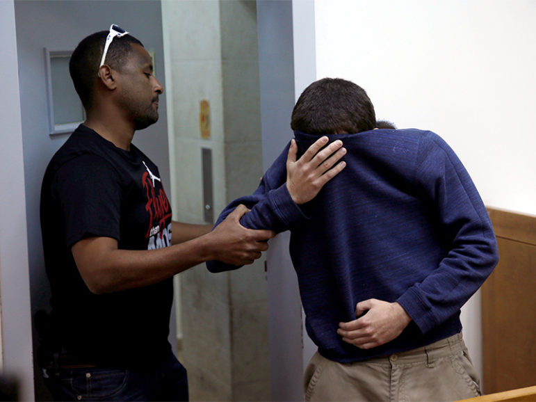 An U.S.-Israeli teen who was arrested in Israel on suspicion of making bomb threats against Jewish community centres in the United States, Australia and New Zealand over the past three months, is seen before the start of a remand hearing at Magistrate's Court in Rishon Lezion, Israel, on March 23, 2017. Photo courtesy of Reuters/Baz Ratner