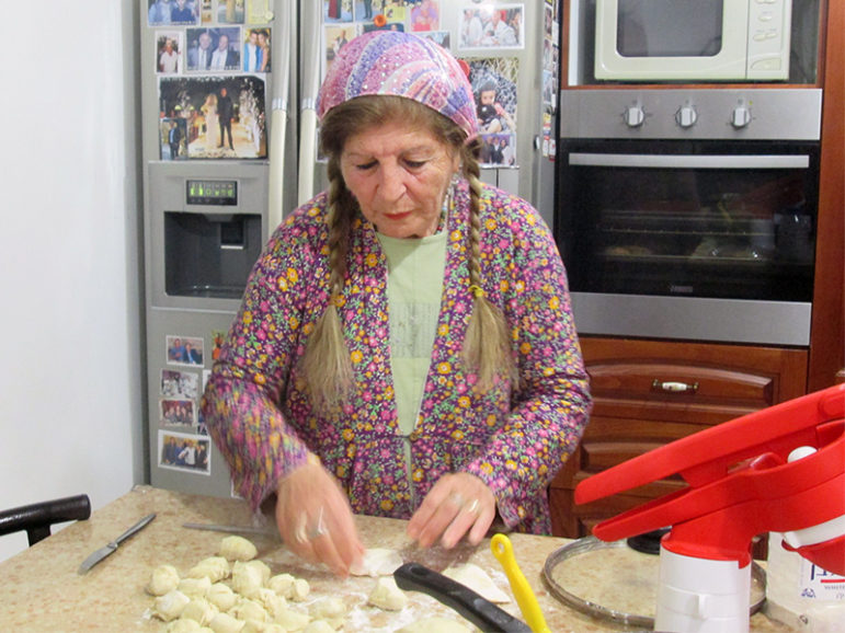 Dalia Harfoof, 66, demonstrates how to make sambusak, a Middle Eastern delicacy, in her kitchen. RNS photo by Michele Chabin