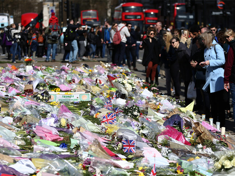 Onlookers view floral tributes in Parliament Square after the attack in Westminster earlier in the week, in central London,  on March 26, 2017. Photo courtesy of Reuters/Neil Hall