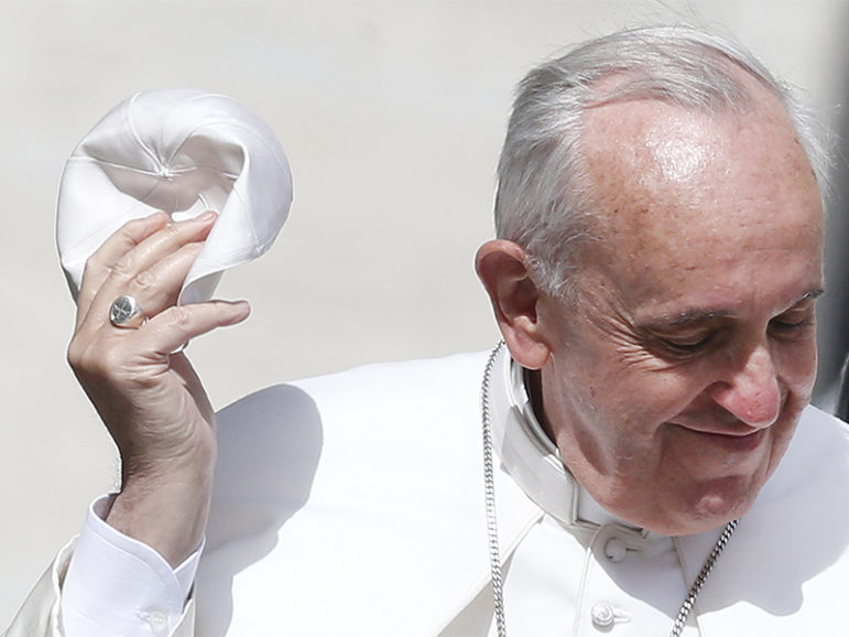 Pope Francis holds his skullcap as he arrives to lead his Wednesday general audience in St. Peter's Square at the Vatican on May 22, 2013. Photo courtesy of Reuters/Tony Gentile