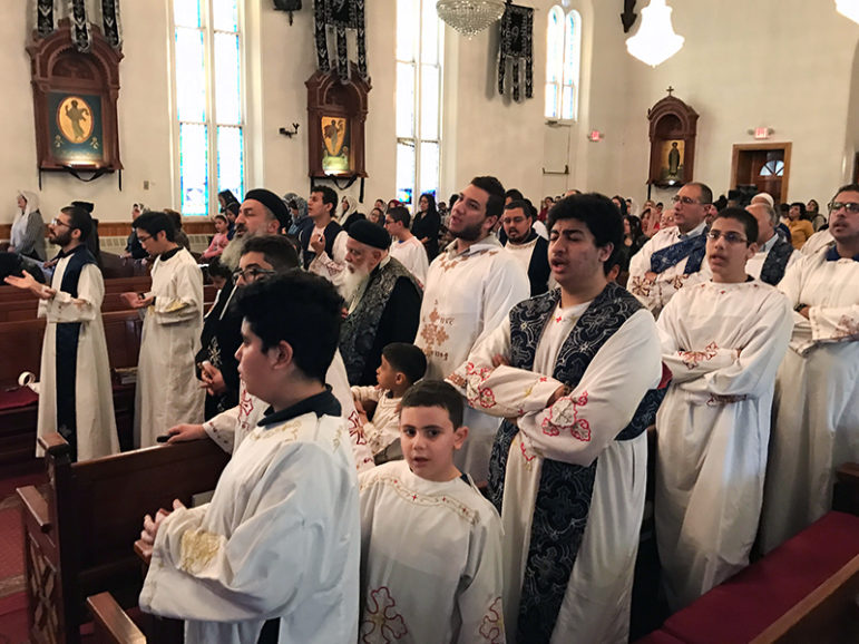 Clergy, deacons and the deacon choir participate in a Holy Week service at the Coptic Orthodox Church of St. Mark on Monday, April 10, 2017, in Jersey City, N.J. Two Coptic Christian churches were bombed in Egypt on Palm Sunday, the day before. RNS photo by Chris Sagona
