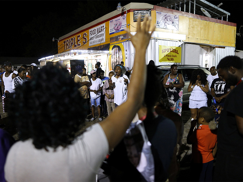 Community members gather during a vigil at the Triple S Food Mart after the U.S. Justice Department announced it will not charge two police officers in the 2016 fatal shooting of Alton Sterling, in Baton Rouge, La., on May 2, 2017. Photo courtesy of Reuters/Jonathan Bachman