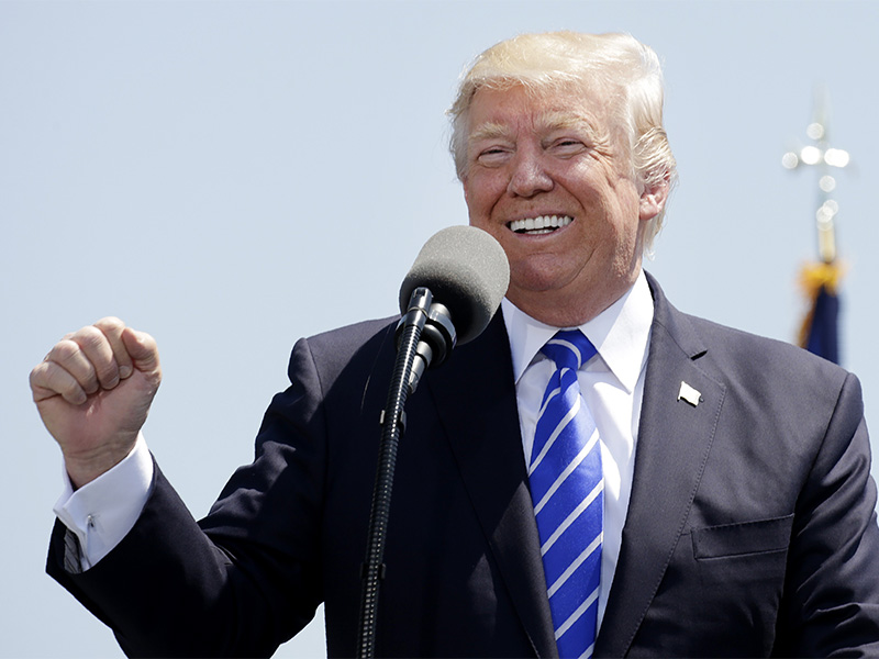 President Trump pumps his fist and smiles as he addresses the graduating class of the U.S. Coast Guard Academy during commencement ceremonies in New London, Conn., on May 17, 2017. Photo courtesy of Reuters/Kevin Lamarque
