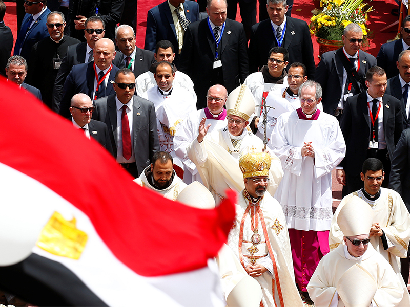 An Egyptian flag flutters in the foreground as Pope Francis waves after a Mass in Cairo on April 29, 2017. Photo courtesy of Reuters/Amr Abdallah Dalsh
*Editors: This photo may only be republished with RNS-POPE-EGYPT, originally transmitted on May 3, 2017.