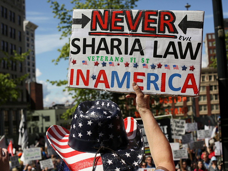 A protester holds a sign during an anti-Sharia rally in Seattle, Washington, U.S., June 10, 2017. Photo courtesy of REUTERS/David Ryder
