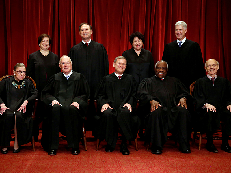 U.S. Chief Justice John Roberts (seated C) leads Justice Ruth Bader Ginsburg (front row, L-R), Justice Anthony Kennedy, Justice Clarence Thomas, Justice Stephen Breyer, Justice Elena Kagan (back row, L-R), Justice Samuel Alito, Justice Sonia Sotomayor, and Associate Justice Neil Gorsuch in taking a new family photo including Gorsuch, their most recent addition, at the Supreme Court building in Washington, D.C., on June 1, 2017. Photo courtesy of Reuters/Jonathan Ernst