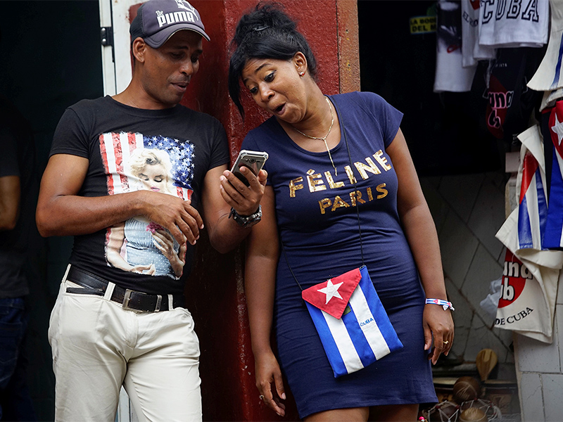 Cuban street vendors wear the U.S. and Cuban colors as they wait for clients in downtown Havana on June 16, 2017. Photo courtesy of Reuters/Alexandre Meneghini