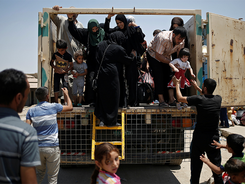 Civilians fleeing the fighting between the Iraqi forces and Islamic State militants arrive at a processing center before being transferred to refugee camps, in western Mosul, Iraq, on June 19, 2017. Photo courtesy of Reuters/Alkis Konstantinidis