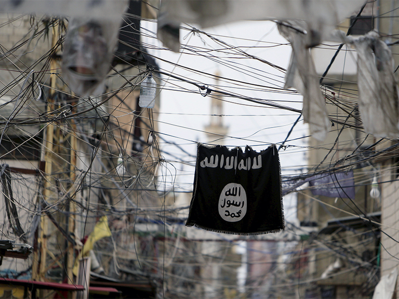 An Islamic State flag hangs amid electric wires over a street in Ain al-Hilweh Palestinian refugee camp near the port-city of Sidon in southern Lebanon on Jan. 19, 2016. Photo courtesy of Reuters/Ali Hashisho