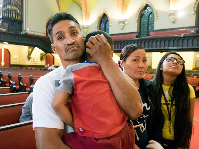 Javier Flores Garcia, an undocumented Mexican immigrant facing deportation, sought and received sanctuary in the Arch Street United Methodist Church in Philadelphia. He cradles his 4-year-old son, Javier, with his wife, Alma, and daughter, Adamaris, by his side inside the church, where he was granted sanctuary on Nov. 13, 2016. Photo courtesy of Philly.com/Ed Hille