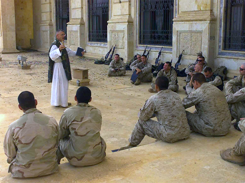 The Rev. Bill Devine, 7th Marine Regiment chaplain, speaks to U.S. Marines assigned to the 5th Marine Regiment during a Catholic Mass at one of Saddam Hussein's palaces in Tikrit, Iraq, on April 19, 2003. Photo by Lance Cpl. Andrew P. Roufs/U.S. Marine Corps/Creative Commons
