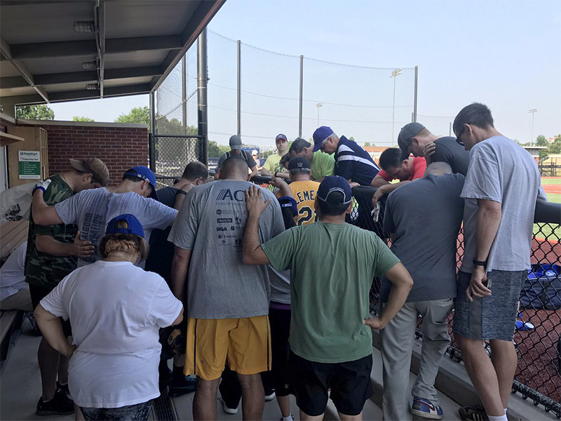 Members of a Democrat congressional baseball team pray in a dugout after hearing about the shooting of Republican colleagues on June 14, 2017, in Washington, D.C. Photo by Rep. Ruben Kihuen via Twitter