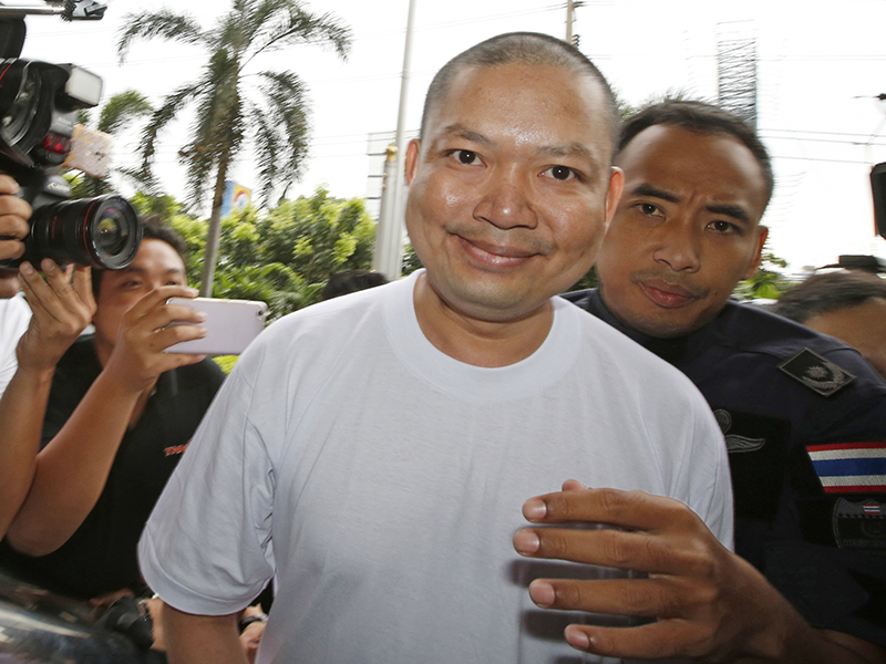 Fugitive ex-monk Wirapol Sukphol is escorted by the Department of Special Investigation officials to the prosecutor's office in Bangkok on July 20, 2017. Wirapol, wanted on charges including child molestation and fraud, is back in Thailand after being extradited from the United States, where he fled in 2013. (AP Photo/Sakchai Lalit)